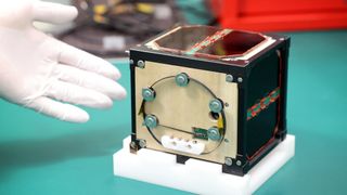 The world's first wooden satellite, LignoSat, developed by scientists at Kyoto University and logging company Sumitomo Forestry, is shown during a press conference at Kyoto University in Kyoto on May 28, 2024. 