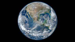 Earth covered with swirling white cloud and deep blue oceans.